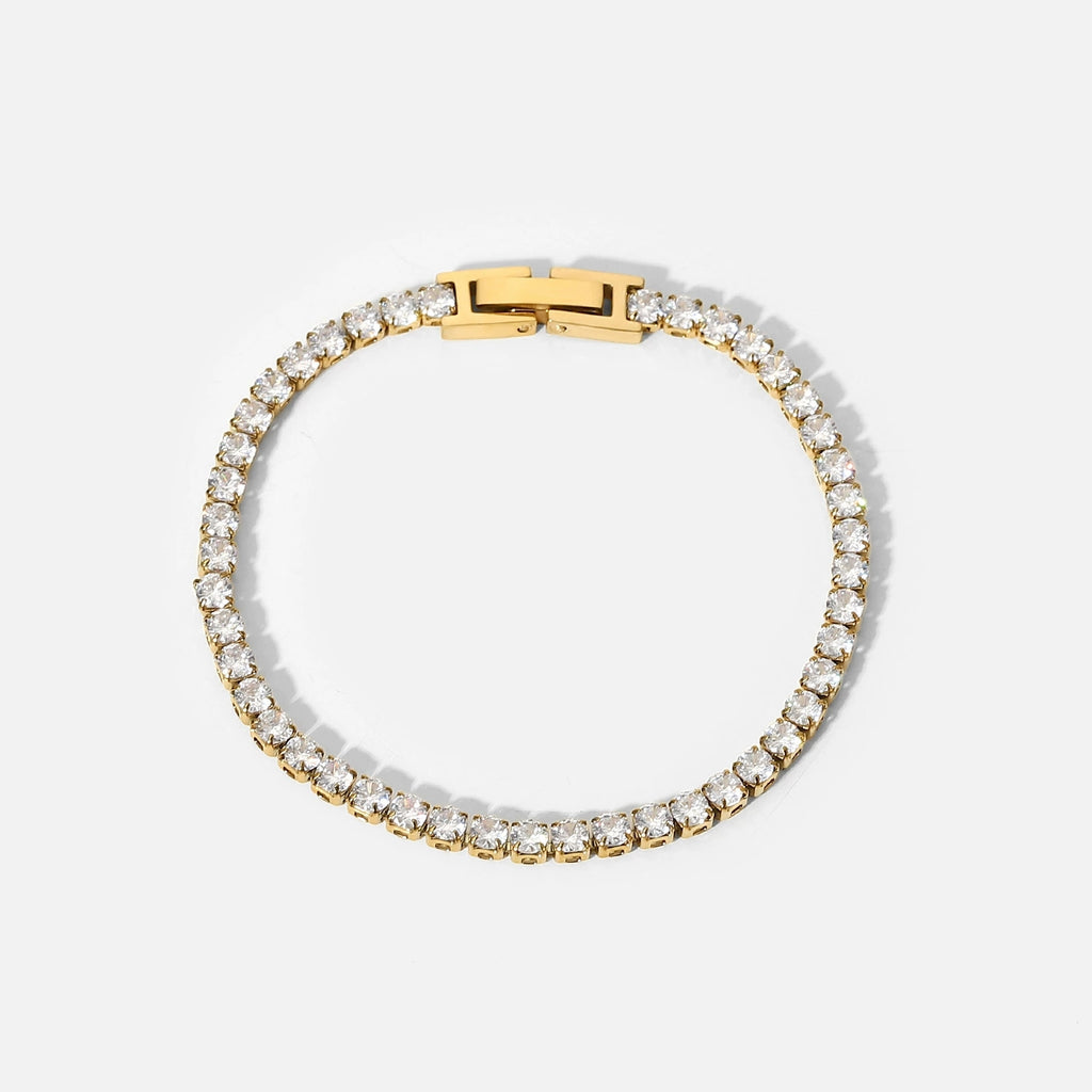 Gold bracelet with clear gemstones on a white background