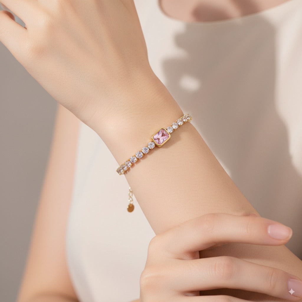 Close-up of a hand wearing a delicate bracelet with a heart-shaped charm on a neutral background