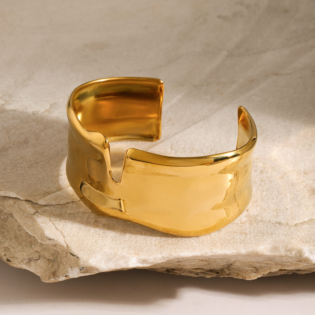 Gold bracelet on a textured stone surface
