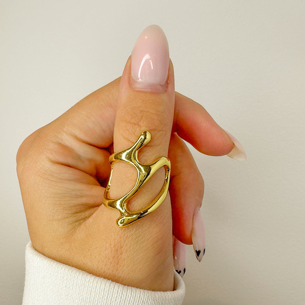 Gold ring on a finger with a plain background
